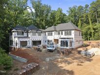 Aerial view of new home featuring brick accents, a multi-car garage, and construction materials at 3601 Alamance Dr, Raleigh, NC 27609