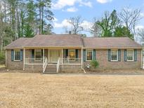 Charming single-story brick home featuring a cozy front porch and manicured lawn at 4707 Stillview Dr, Durham, NC 27712
