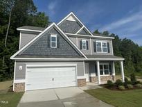 Charming two-story home featuring a two-car garage and a combination of lap siding and shake accents at 507 Olivia Crossing Ct # 20, Four Oaks, NC 27524