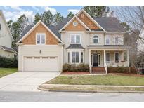 Charming two-story home featuring mixed material exterior, manicured lawn, and attached two-car garage at 514 Grant Forest Ln, Cary, NC 27519