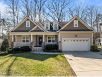 Charming home featuring a welcoming front porch, a two-car garage and well-maintained landscaping at 55 Fox Chapel Ln, Pittsboro, NC 27312