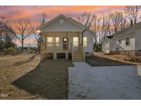 Charming front exterior with a cozy porch and fresh concrete driveway at 614 Gilmer St, Burlington, NC 27217