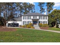 Stately white brick home with a manicured lawn, black shutters, and a charming front entrance at 2605 Ridge Rd, Raleigh, NC 27612