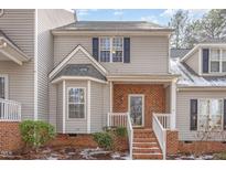 Charming townhouse featuring a light gray exterior, brick accents, and a welcoming front entrance at 2623 Broad Oaks Pl, Raleigh, NC 27603