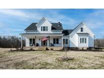 Charming two-story home with a inviting front porch, American flag and well-maintained lawn at 3344 Cobb Farm Trl, Mebane, NC 27302