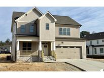 Charming two-story home showcasing a neutral color palette, attached two-car garage, and covered front porch at 3521 Amelia Grace Dr # 67, Fuquay Varina, NC 27526