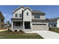 Charming two-story home boasts a two-car garage, inviting front porch, and manicured lawn at 3521 Amelia Grace Dr # 67, Fuquay Varina, NC 27526