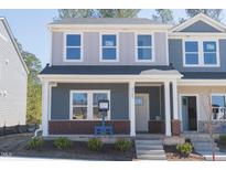 Charming two-story home with brick accents, covered porch, and neat landscaping at 3723 Rosebush Dr, Zebulon, NC 27597