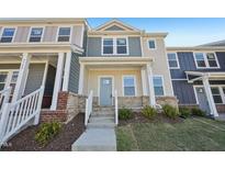 Charming townhome featuring a light yellow exterior with a welcoming covered front porch at 3725 Rosebush Dr, Zebulon, NC 27597