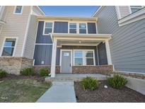 Charming two-story townhome with blue siding, brick accents and inviting front porch at 3727 Rosebush Dr, Zebulon, NC 27597