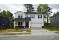 Charming two-story home with a white exterior, black shutters, and a well-manicured lawn at 3817 Rosebush Dr, Zebulon, NC 27597