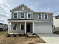 Charming two-story home with a grey exterior, a two-car garage, and a well-maintained front yard at 4120 Shadbush St, Raleigh, NC 27616