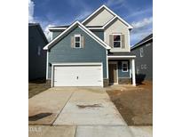 Two-story home featuring a front-facing garage and a mix of horizontal and shake siding at 60 Commons Cir, Clayton, NC 27520