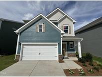 Charming two-story home featuring a two-car garage, craftsman-style details, and a welcoming front porch at 60 Commons Cir, Clayton, NC 27520