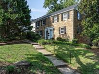 Stone-clad exterior with black shutters and a walkway leading to the front door of this charming townhome at 979 St Marys St # G6, Raleigh, NC 27605