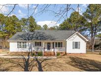 Charming single-story home featuring a welcoming front porch, brick foundation, and manicured lawn at 1001 Strobus Ct, Wendell, NC 27591