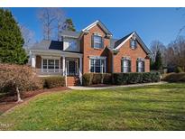 Charming brick home with a well-manicured lawn and inviting front porch at 10700 Chesson Dr, Raleigh, NC 27614