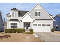Charming two-story home featuring a manicured lawn and attached two-car garage at 130 Ivory Ln, Raleigh, NC 27610