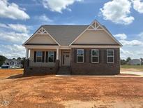 New construction home with gray brick and beige siding, complemented by professionally designed architectural details at 190 Sage Ln # 015, Four Oaks, NC 27524