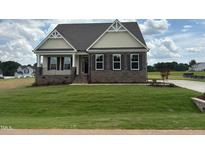 Charming single-story home with stone accents, a well-manicured lawn, and welcoming curb appeal at 190 Sage Ln # 015, Four Oaks, NC 27524