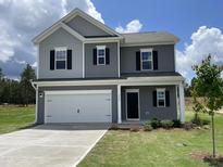 Charming two-story home featuring gray siding, black shutters, a white garage door, and a well-manicured lawn at 209 Deodora Ln, Cameron, NC 28326