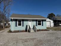 Charming single-story home featuring light blue siding, black shutters, and a well-maintained front yard at 212 Craig Ave, Henderson, NC 27537