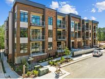 Modern apartment building with brick facade and balconies, offering stylish urban living at 2441 Campus Shore # 402, Raleigh, NC 27606