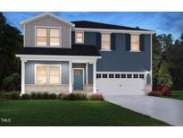 Two-story home featuring blue siding, a covered porch, a two-car garage, and manicured landscaping at 3833 Rosebush Dr, Zebulon, NC 27597