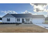 Charming single-story home with a manicured lawn, an attached two-car garage and a classic design at 59 N Movado Trl, Kenly, NC 27542