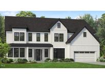 Charming two-story home featuring a modern farmhouse design with white siding, black trim, and a well-manicured lawn at 824 Timber Mist Ct, Cary, NC 27519