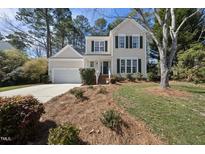 Charming two-story home with light yellow siding, green shutters, a front yard, and an attached one-car garage at 102 Ashley Brook Ct, Cary, NC 27513