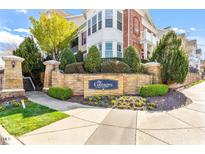 View of The Cottages at Brier Creek entrance sign with stone landscaping and beautiful greenery at 10321 Sablewood Dr # 108, Raleigh, NC 27617