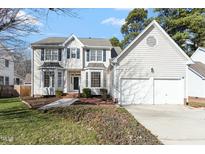 Traditional two-story home boasts a two-car garage, landscaped yard, and welcoming front entrance with beautiful architectural details at 11820 Fairlie Pl, Raleigh, NC 27613