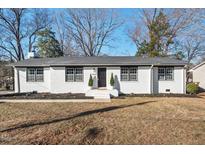 Charming renovated brick home with black trim and a well-manicured lawn at 1204 Donphil Rd, Durham, NC 27712