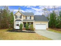 Charming two-story home featuring a two-car garage, black shutters, and a well-manicured front yard at 1226 Woodland Church Rd, Wake Forest, NC 27587