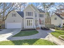 Charming two-story home featuring a well-manicured lawn, brick walkway, and attached two car garage at 1600 Patterson Grove Rd, Apex, NC 27502