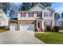 Inviting two-story home featuring a stone facade, red shutters, and a well-manicured lawn at 211 Whitney Ln, Durham, NC 27713