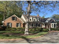 Charming brick home featuring manicured landscaping, black shutters, and a brick driveway at 30 Brookside Place, Durham, NC 27705