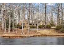 Charming brick home surrounded by mature trees and a serene pond view at 3120 Timberlyne Dr, Mebane, NC 27302