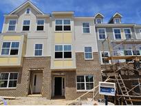 New townhome features brick facade and multiple windows under a bright blue sky at 332 Chesapeak Commons St # 141, Garner, NC 27529