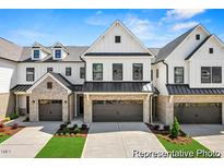 Charming townhome exterior boasts brick accents, a two-car garage, and a well-manicured lawn at 46 N District Ave # 251, Clayton, NC 27527