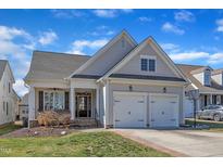 Charming home with a two-car garage, covered front porch, and a well-manicured lawn at 7025 Dayton Ridge Dr, Apex, NC 27539
