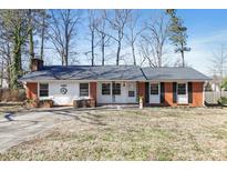 Charming one-story brick home with a well-maintained front yard and a welcoming entrance at 9013 Langwood Dr, Raleigh, NC 27617