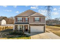 Charming two-story home with a two-car garage and stone accents at 110 Lodgepole Ln, Burlington, NC 27215