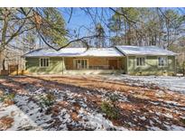 Charming single-story home with a stone and siding exterior and a snow-covered lawn at 11408 Hickory Grove Church Rd, Raleigh, NC 27613