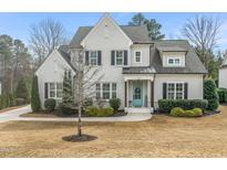 Charming two-story home featuring painted brick, a covered entryway, and professionally landscaped yard at 1301 Mackinaw Dr, Wake Forest, NC 27587