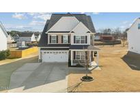 Charming two-story home featuring a two car garage and well maintained lawn at 140 Southern Acres Dr, Fuquay Varina, NC 27526