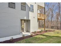 Side exterior of home with a small balcony, landscaping and secondary entrance at 4501 Mint Leaf Ln, Raleigh, NC 27612