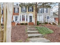 Charming townhomes with brick and siding exteriors and well-maintained front lawns and landscaped front yard at 4523 Hamptonshire Dr, Raleigh, NC 27613