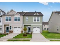 Charming townhome featuring a one-car garage and manicured front lawn at 46 Shay St, Angier, NC 27501